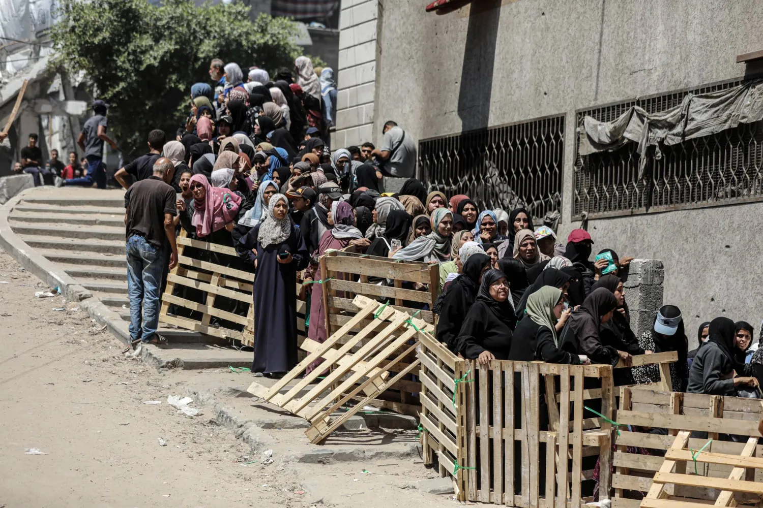 فلسطينيون يصطفّون للحصول على مساعدات غذائية من برنامج الأغذية العالمي بمدينة غزة 12 يوليو 2025 (د.ب.أ)