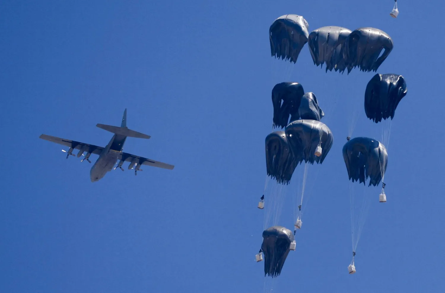 طائرة تلقي مساعدات إنسانية فوق غزة يوم الأحد (رويترز)