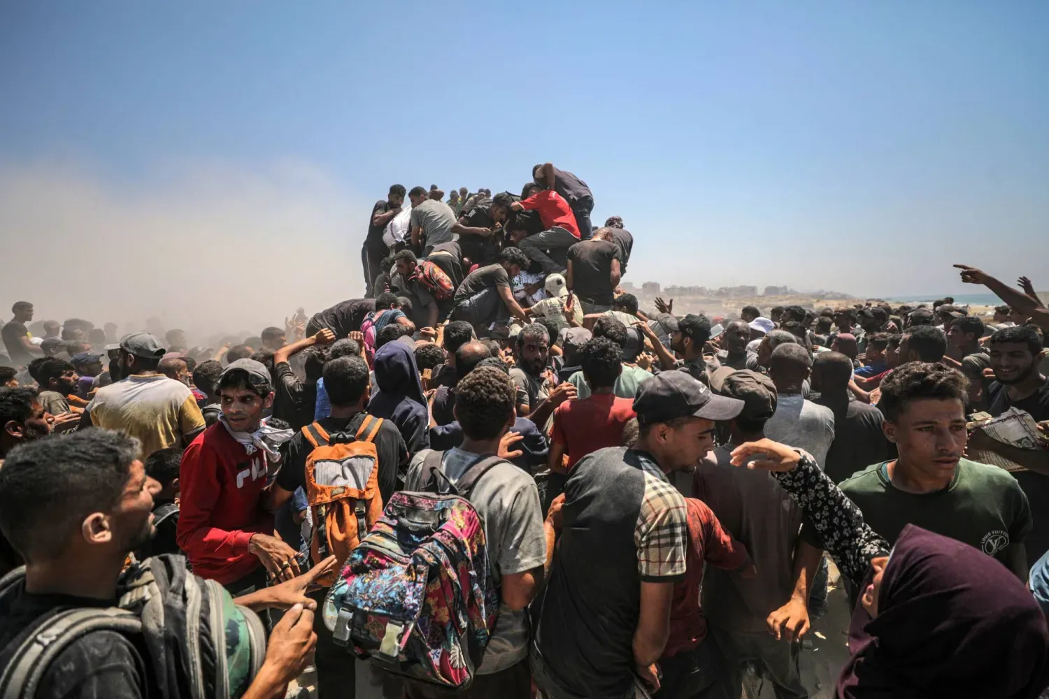 Gazze Şeridi'nin kuzeyinde bir yardım kamyonundan un almak için toplanan yerlerinden edilmiş Filistinliler, 27 Temmuz (EPA)