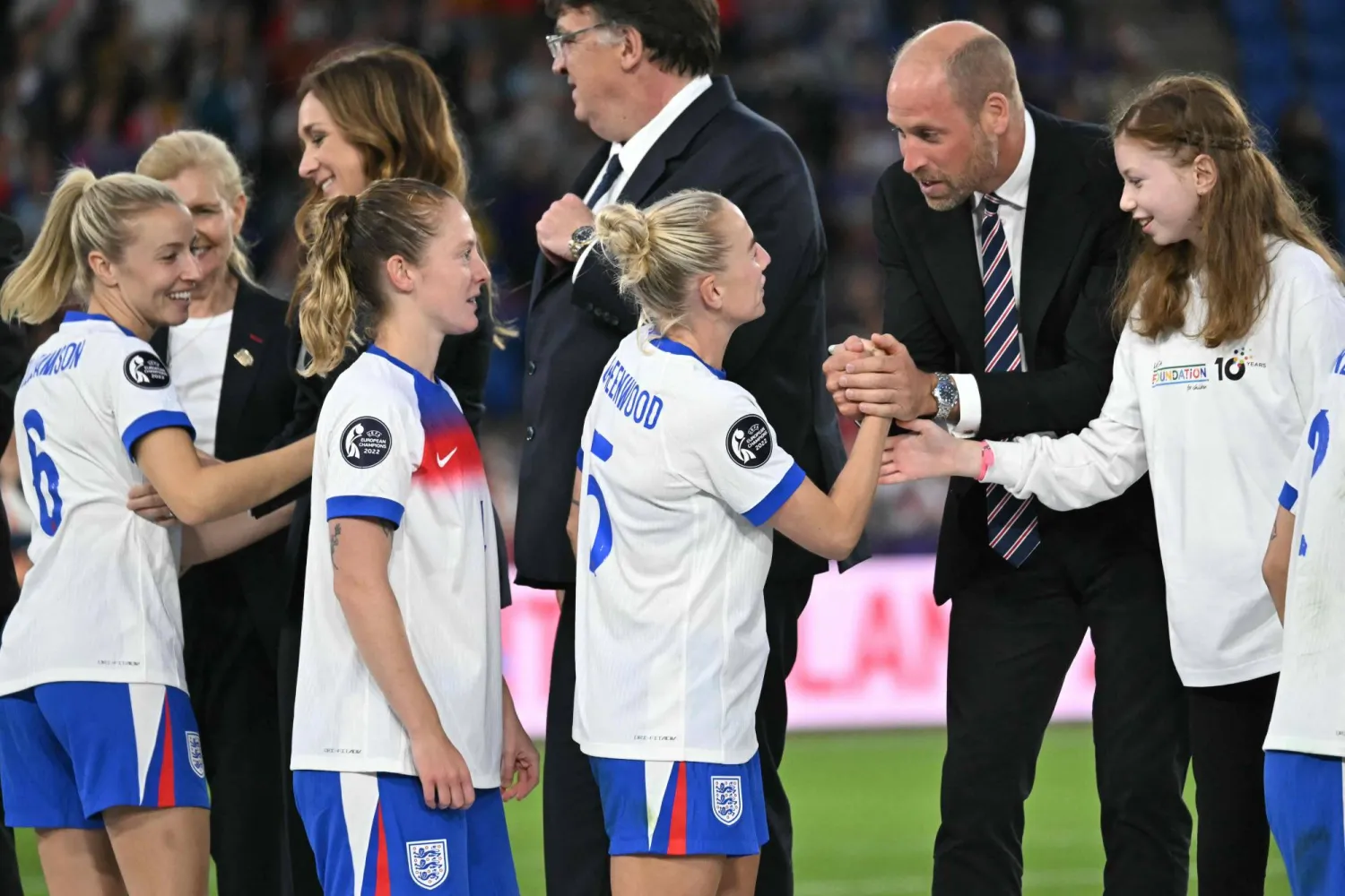 الأمير ويليام ولي عهد بريطانيا يصافح لاعبات منتخب إنجلترا بطلات اليورو (أ.ف.ب)