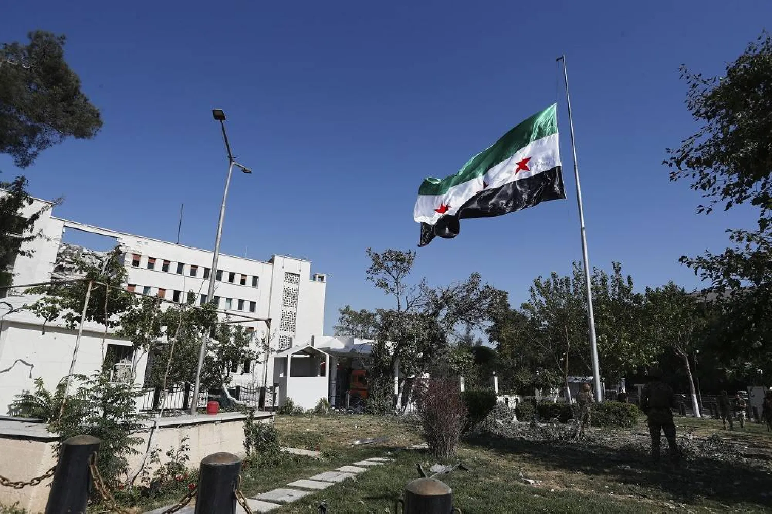 Syrian soldiers raise the Syrian national flag in front of the Syrian Defense Ministry building, which was heavily damaged by Israeli airstrikes last Wednesday, in Damascus, Syria, Saturday, July 19, 2025. (AP) 