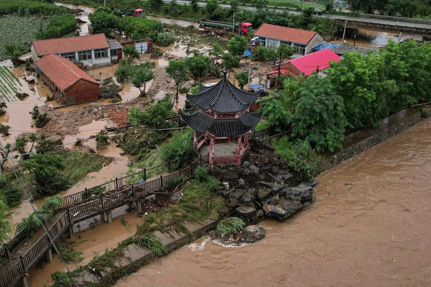 An aerial view shows damaged buildings after heavy rains at Xin'anzhuang village, in Miyun district, on the outskirts of Beijing on July 28, 2025. (AFP)