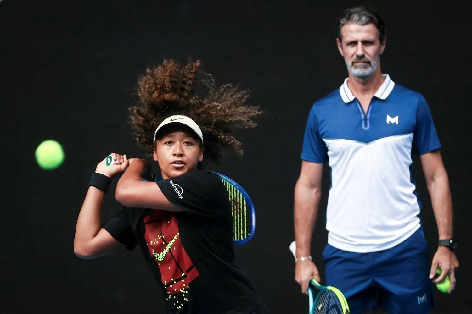 This file photo taken on January 9, 2025 shows Japan’s Naomi Osaka (L) hitting a return as her coach Patrick Mouratoglou watches during a training session ahead of the Australian Open tennis tournament in Melbourne. (AFP) 