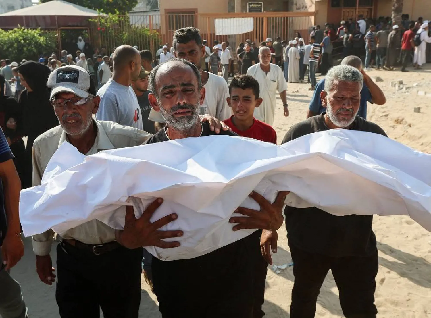 A mourner carries the body of a Palestinian killed in an overnight Israeli strike, according to medics, during a funeral at Nasser hospital, in Khan Younis in the southern Gaza Strip, July 28, 2025. (Reuters)
