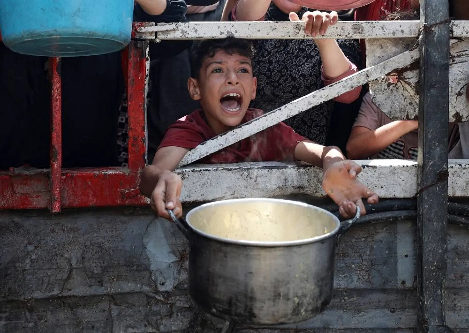 A Palestinian reacts as he waits to receive food from a charity kitchen, amid a hunger crisis, in Gaza City, July 28, 2025. (Reuters)