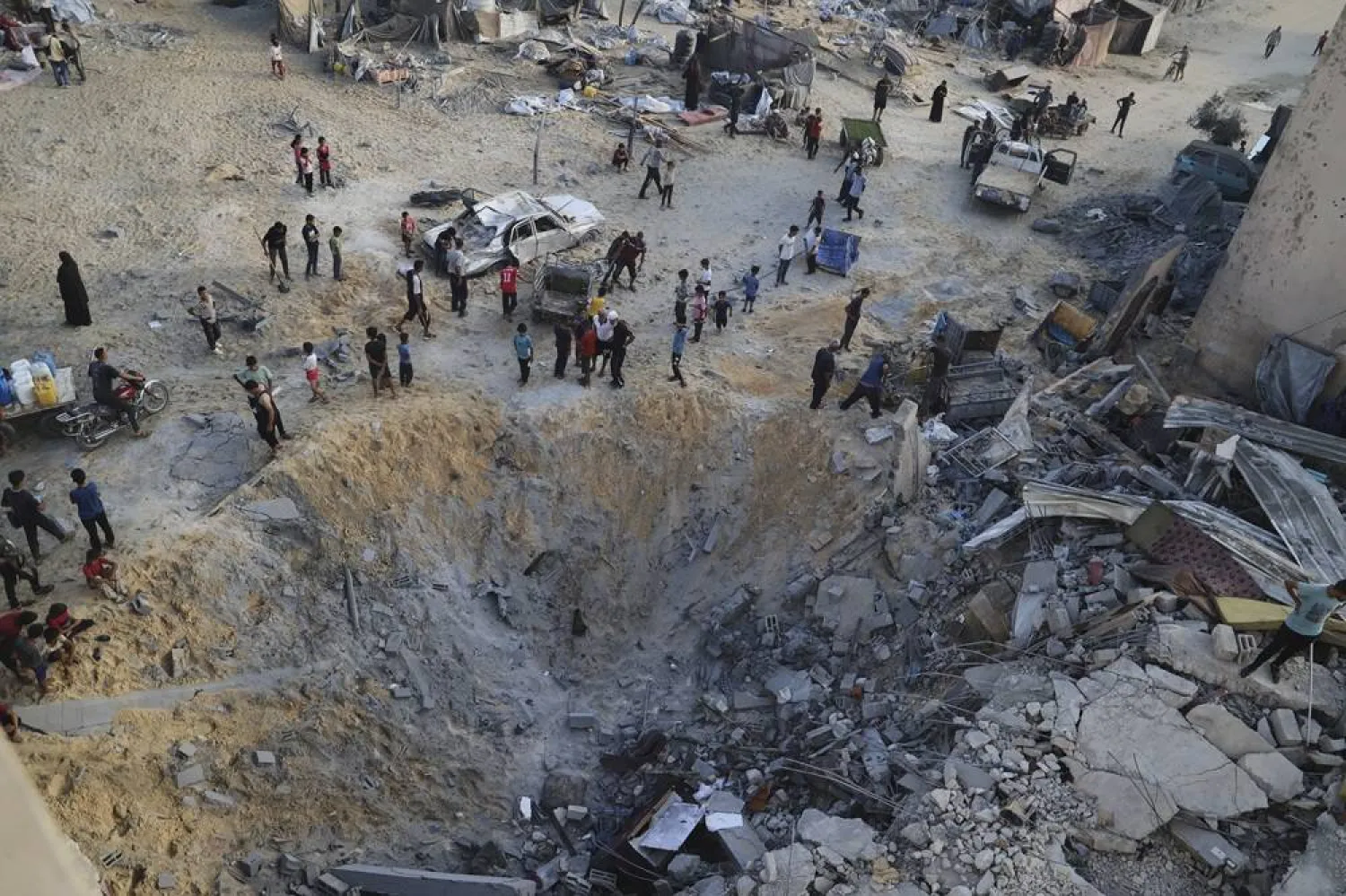  Palestinians inspect the site struck by an Israeli bombardment in Muwasi, Khan Younis, Gaza Strip, Monday, July 28, 2025. (AP) 