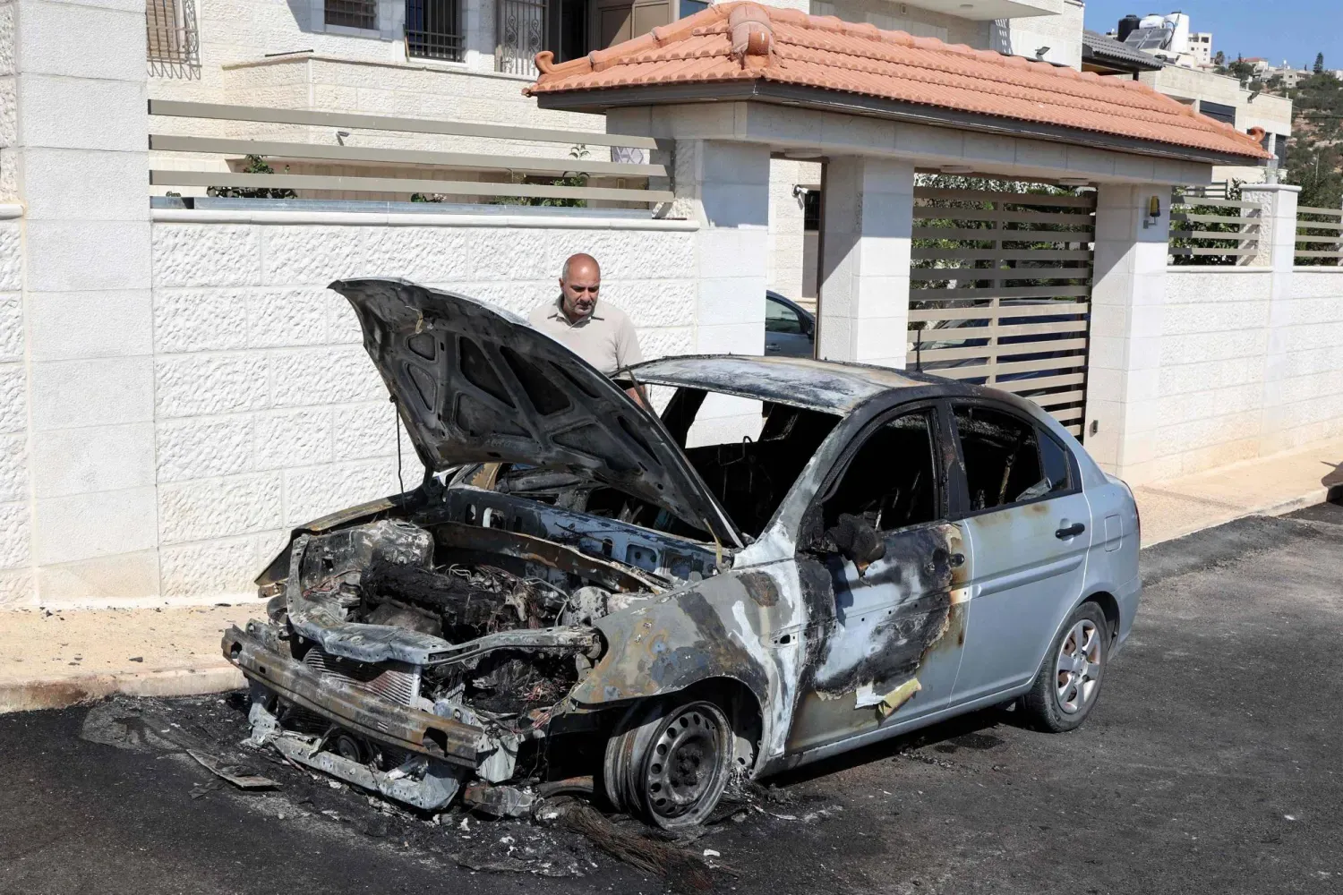 Ramallah'ın kuzeydoğusundaki Hıristiyan kasabası Taybeh'de dün şafak vakti yerleşimciler tarafından ateşe verilen bir araç (AFP)