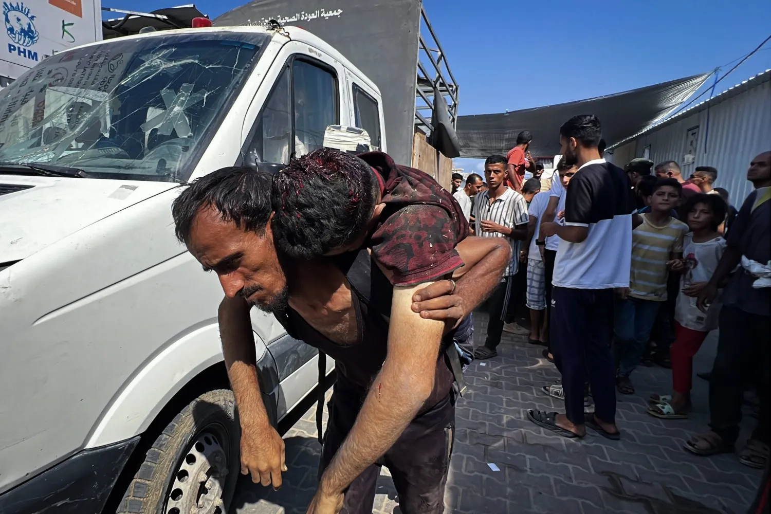 فلسطينيون ينقلون جرحى إلى مستشفى العودة في مخيم النصيرات (د.ب.أ)