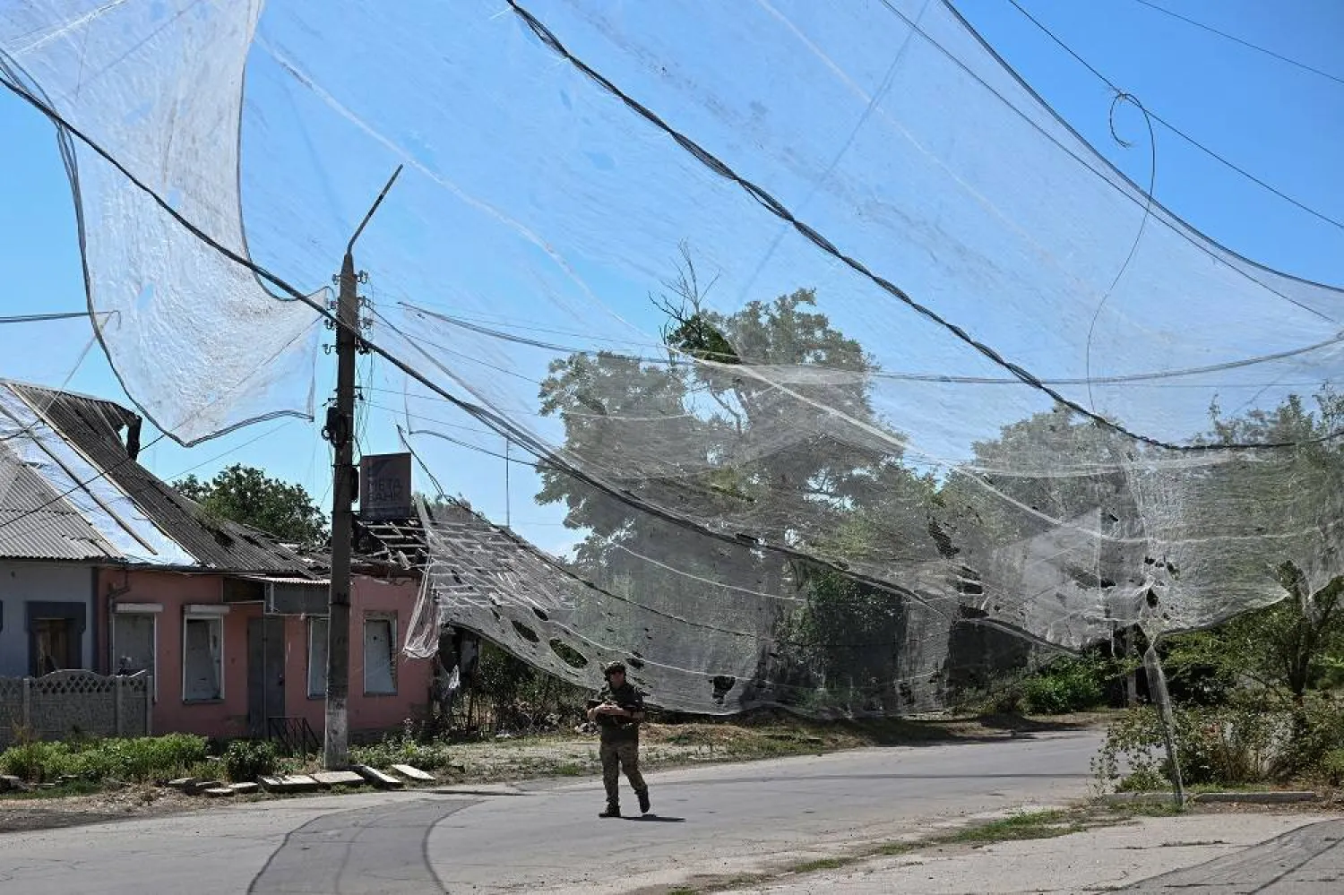 A Ukrainian service member walks on a street protected with anti-drone nets, amid Russia's attack on Ukraine, in the frontline town Orikhiv in Zaporizhzhia region, Ukraine July 23, 2025. (Reuters) 