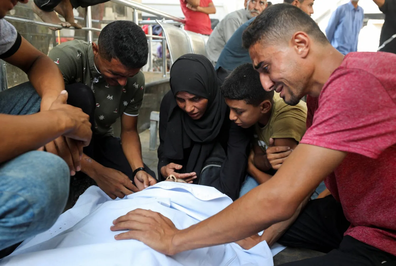 عائلة تودّع أقاربها الذين قُتلوا أمس بنيران إسرائيلية في أثناء محاولتهم تلقي المساعدة (رويترز)