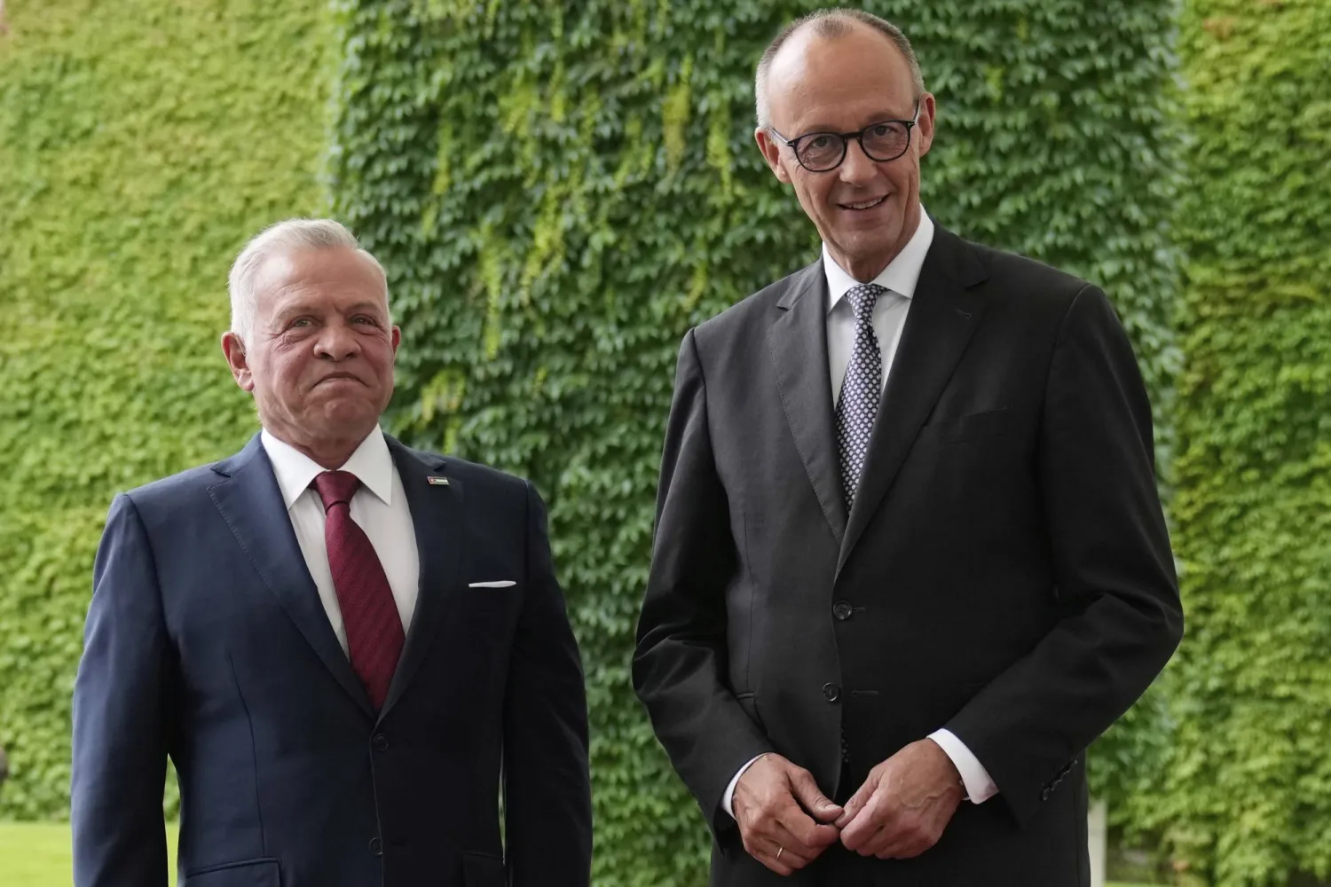 المستشار الألماني مستقبلاً العاهل الأردني في برلين اليوم (أ.ب)