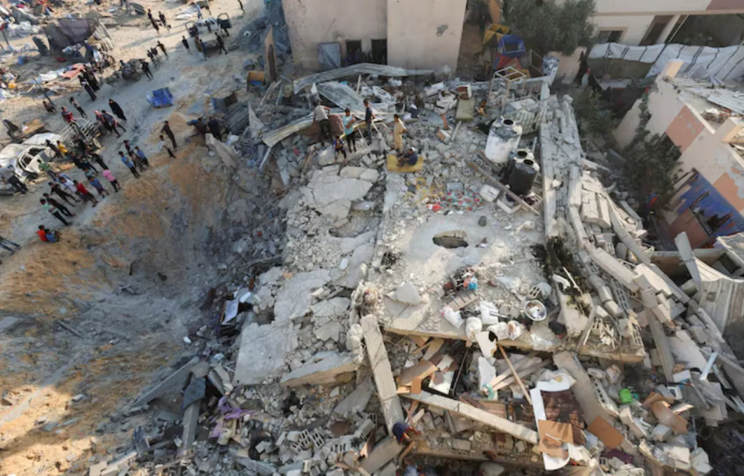 Palestinians gather at the site of an overnight Israeli air strike on a house, in Khan Younis in the southern Gaza Strip, July 28, 2025. REUTERS/Ramadan Abed/File Photo 