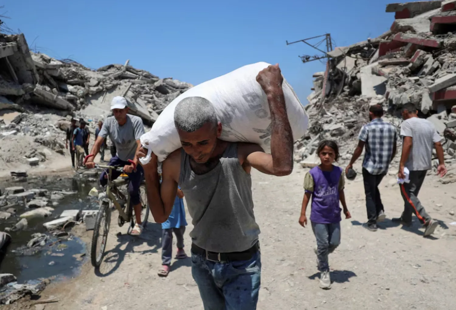 A Palestinian carries a bag with aid supplies that entered Gaza through Israel, in Beit Lahia, northern Gaza Strip, July 27. REUTERS/Mahmoud Issa 