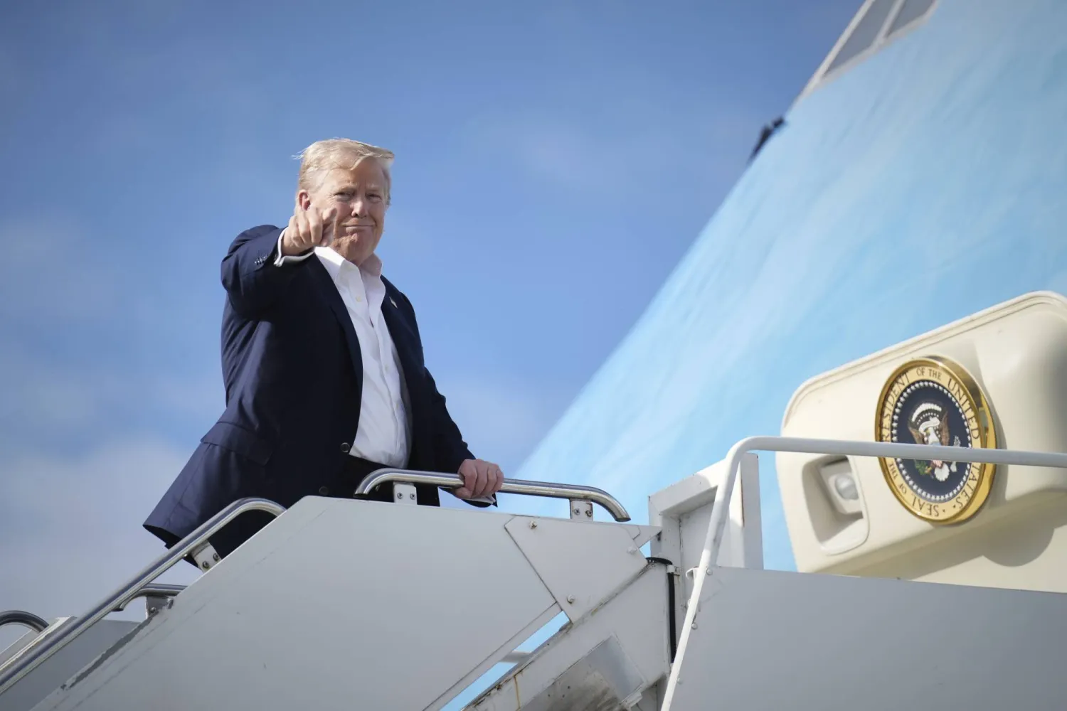 الرئيس الأميركي دونالد ترمب يلوّح بيده في أثناء صعوده إلى الطائرة الرئاسة في 29 يوليو 2025 في قاعدة لوسيموث الجوية الملكية في بريطانيا في طريقه إلى واشنطن (أ.ب)