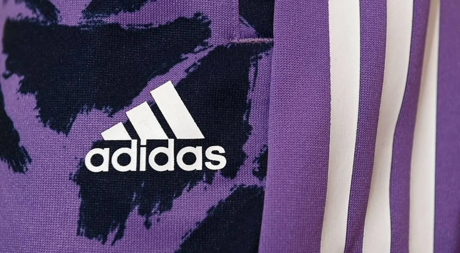 The logo of the German sports equipment maker Adidas is pictured prior to the company's annual press conference in Herzogenaurach, southern Germany on March 8, 2023. (AFP)