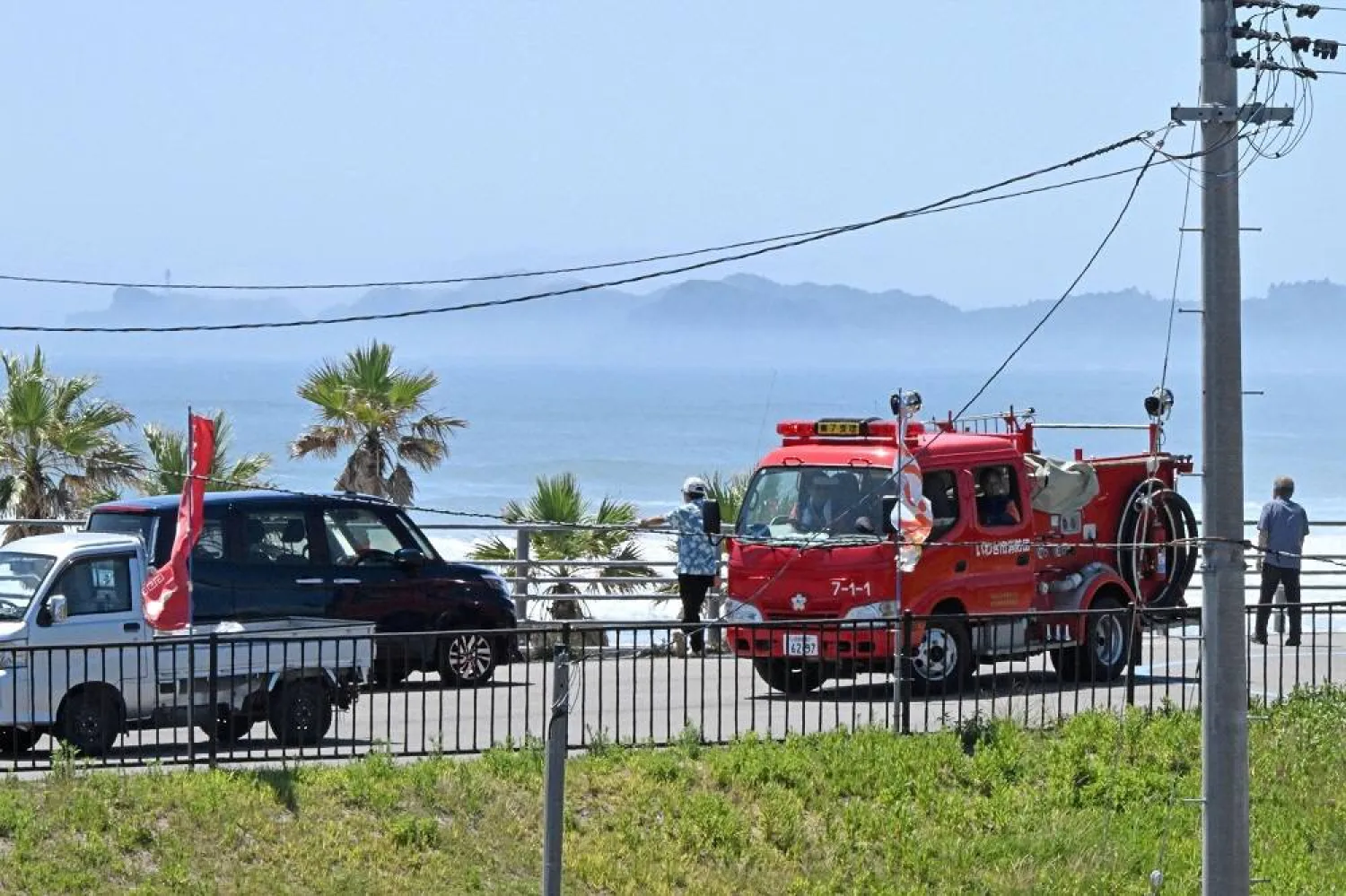 People watch the coast area from higher ground after Japan issued evacuation alert following major quake in Russia's Kamchatka Peninsula that triggered a tsunami warning, at Yotsukura beach in Iwaki, Fukushima prefecture, Japan July 30, 2025, in this photo taken by Kyodo. (Kyodo/via Reuters)