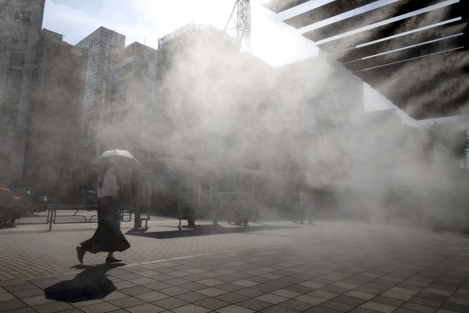 A passerby walks past a cooling mist station during a heatwave in Tokyo, Japan, 24 July 2025. (EPA) 