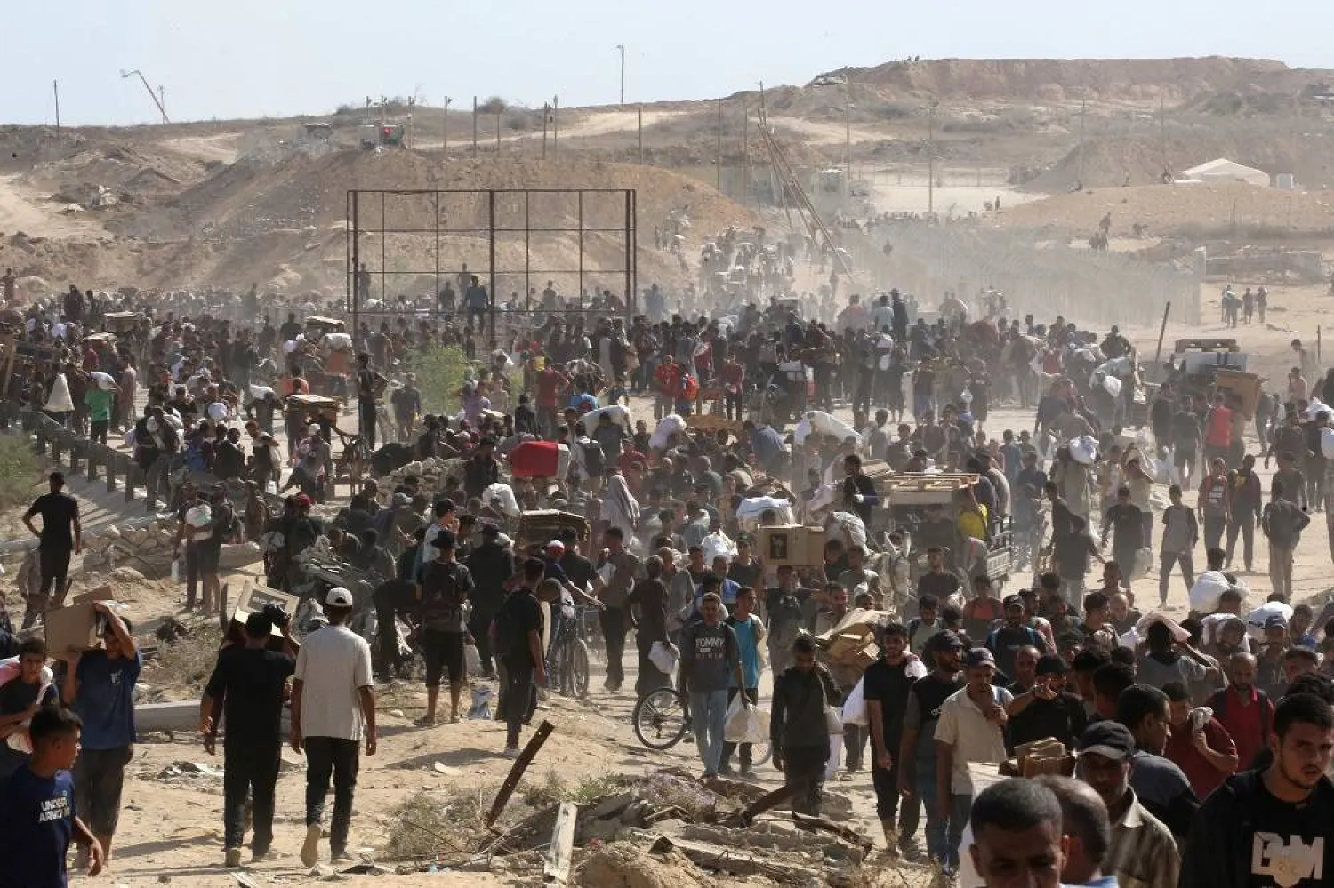 Displaced Palestinians gather to receive aid from a GHF aid distribution point at the so-called "Netzarim corridor" in the central Gaza Strip on July 30, 2025. (AFP)