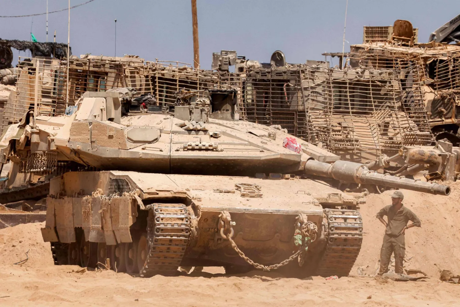 جندي من الجيش الإسرائيلي يقف بجوار دبابة قتال رئيسية في موقع على الحدود مع قطاع غزة جنوب إسرائيل يوم 29 يوليو 2025 (أ.ف.ب)