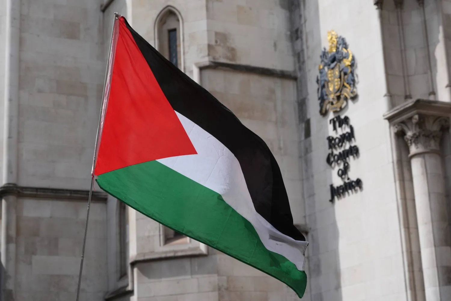 علم فلسطين خارج مبنى المحاكم الملكية في وسط لندن حيث يُصدر قاضٍ قراراً بشأن ما إذا كان بإمكان هدى عموري المؤسِّسة المشارِكة لحركة «فلسطين أكشن» الشروع في طعن قانوني ضد قرار وزيرة الداخلية بتصنيف الحركة منظمةً إرهابية (د.ب.أ)