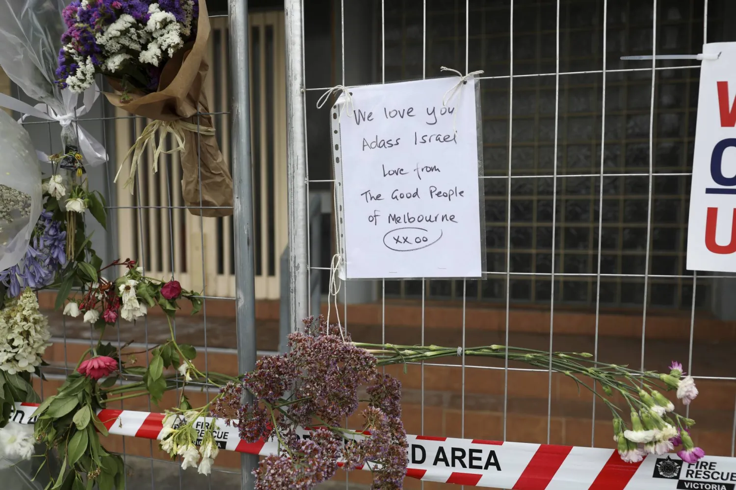 A sign and flowers are displayed at the damaged Adass Israel Synagogue in Melbourne, Australia, on Dec. 9, 2024, after a firebombing. (Con Chronis/AAP Image via AP)
