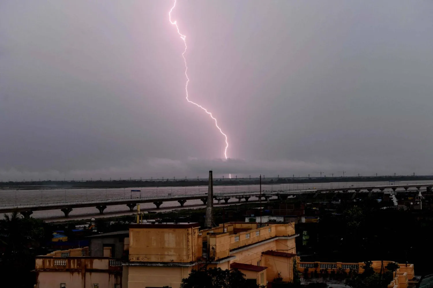 Lightning strikes over the grey sky during monsoons in Patna on July 16, 2025. (Photo by Sachin KUMAR / AFP)