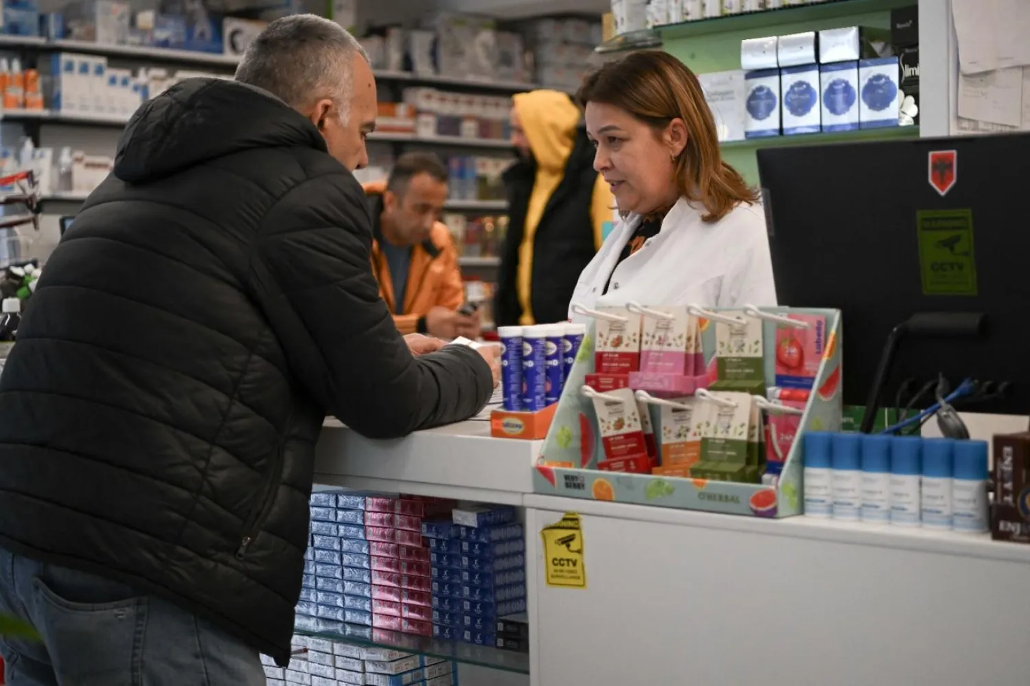 Priştine'deki bir eczane sahibi müşterisiyle konuşuyor (Temsili/AFP)