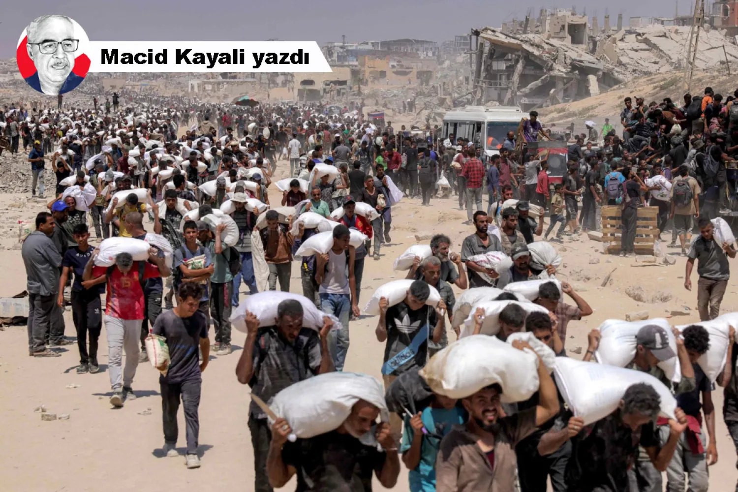 Gazze'nin kuzeyindeki Zikim Sınır Kapısı yakınlarında dağıtılan un çuvallarını omuzlarında taşıyan Gazzeliler (AFP)
