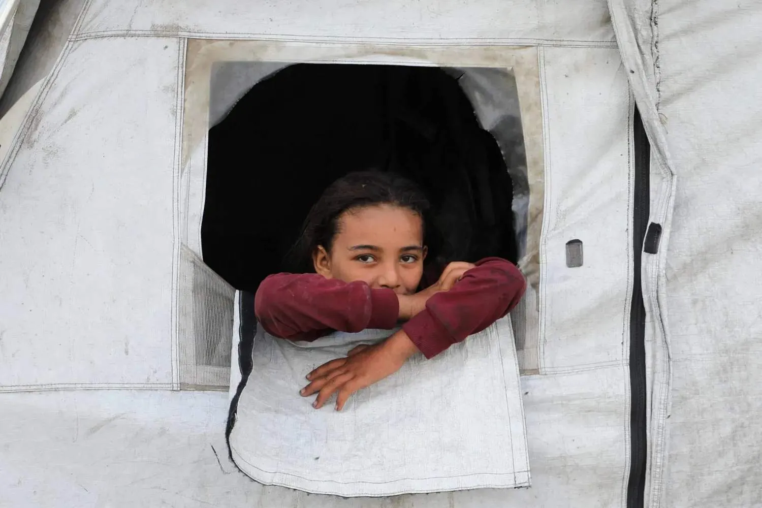 İsrail ordusu, halkı Gazze'nin güneyine nakletmeye hazırlanırken ailesinin sığındığı çadırdan dışarı bakan Filistinli bir kız çocuğu (Reuters)