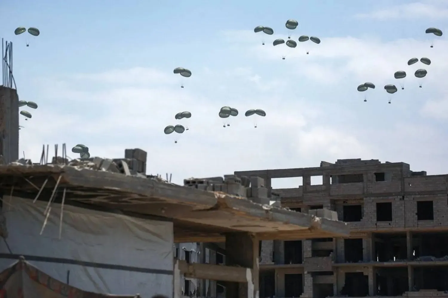 A picture taken in northern Gaza's Jabalia shows aid parcels parachuted down following an airdrop above the Israel-besieged Palestinian territory on August 1, 2025. (AFP)