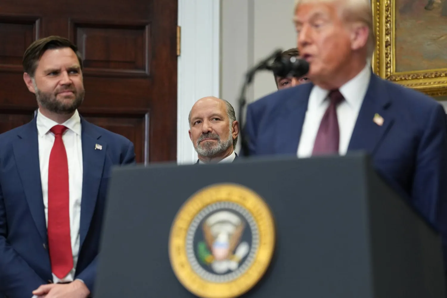 الرئيس الأميركي دونالد ترمب ونائبه جي دي فانس وبينهما وزير التجارة هوارد لوتنيك في مؤتمر صحافي بالبيت الأبيض للإعلان عن الأوامر التنفيذية الجديدة مساء الخميس (إ.ب.أ)