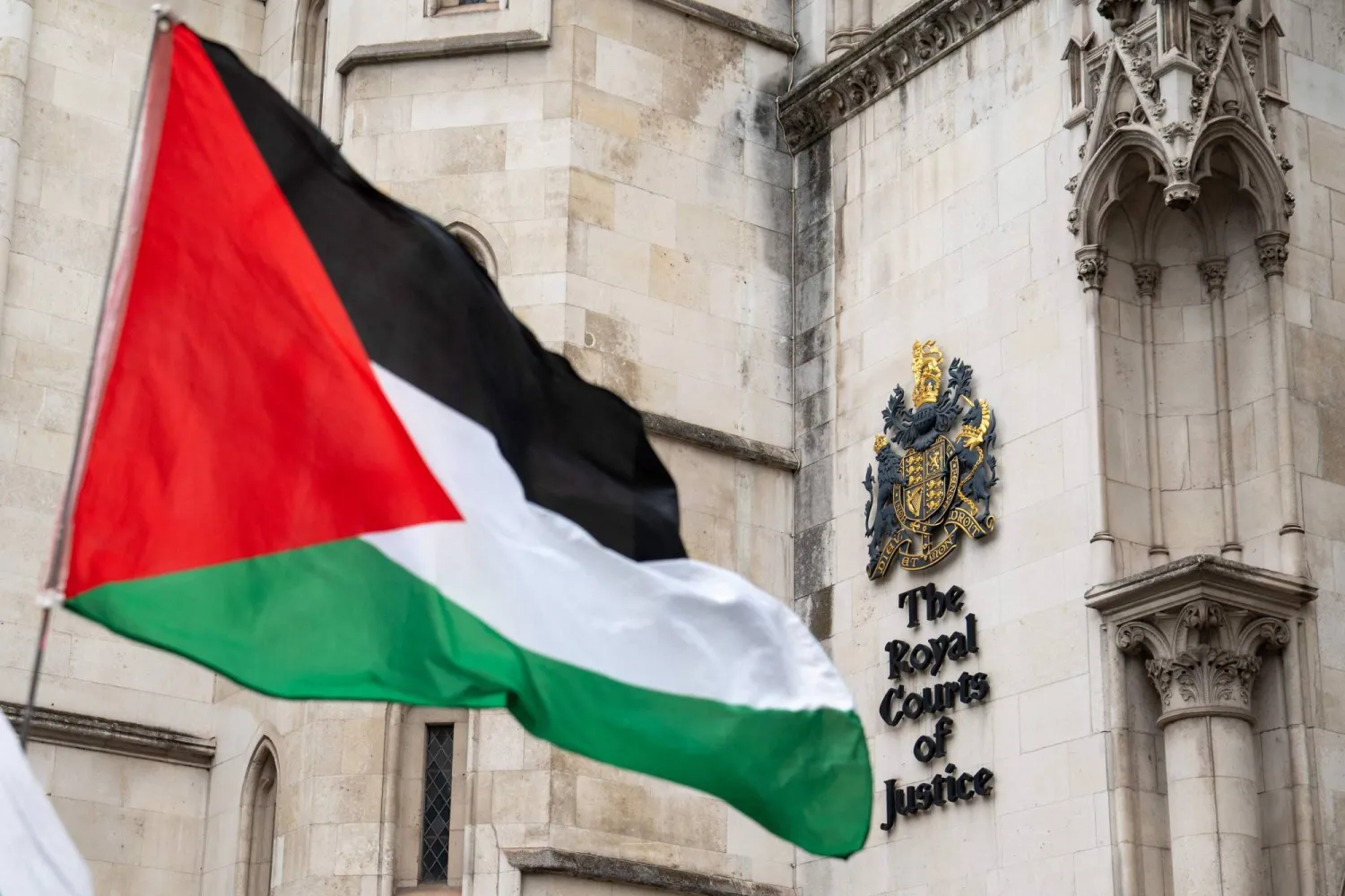 A Palestinian flag is seen held outside the Royal Courts of Justice in London on July 30, 2025. (Photo by Niklas HALLE'N / AFP)