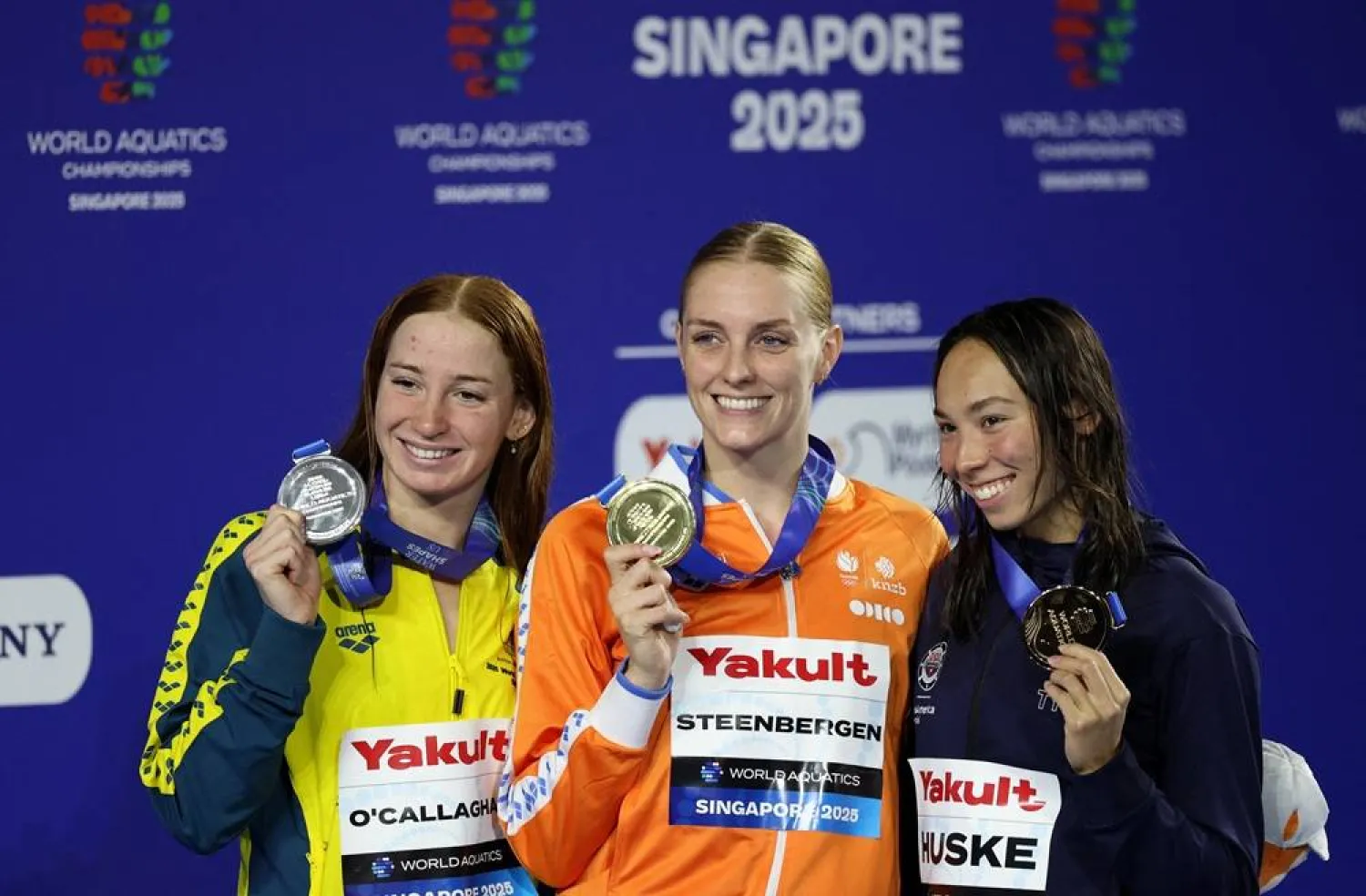 Swimming - World Aquatics Championships - Women 100m Freestyle - World Aquatics Championships Arena, Singapore - August 1, 2025 Gold medalist Netherlands' Marrit Steenbergen celebrates on the podium alongside silver medalist Australia's Mollie O'Callaghan and bronze medalist Torri Huske of the US. (Reuters) 
