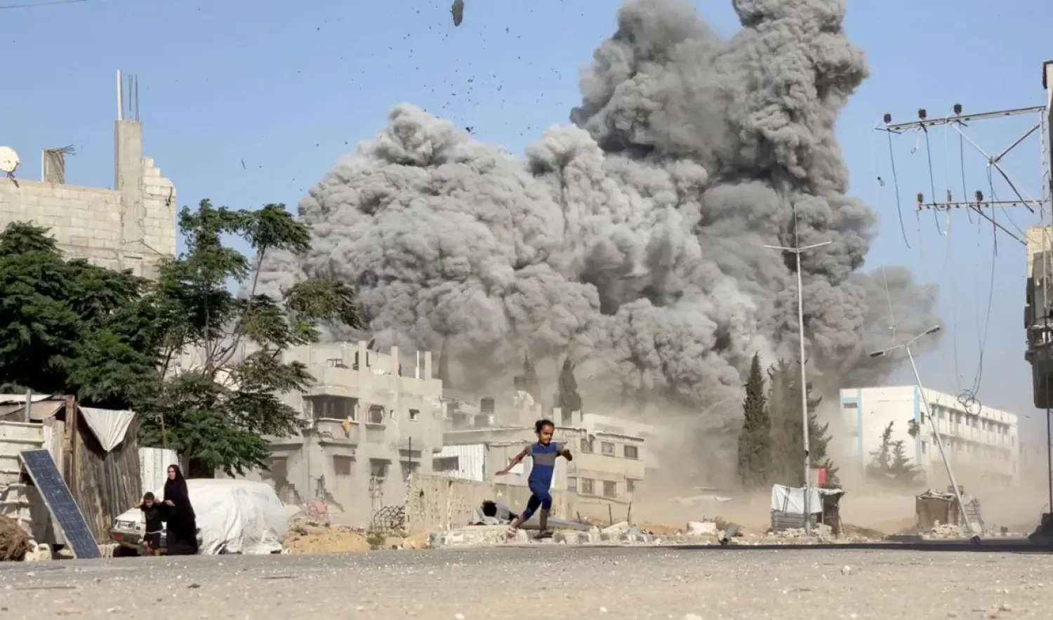 A girl runs from the scene after Israeli strikes on a school sheltering displaced people at the Bureij refugee camp in the central Gaza Strip, July 17, 2025, in this screen grab from a video obtained by Reuters. Handout via REUTERS.
