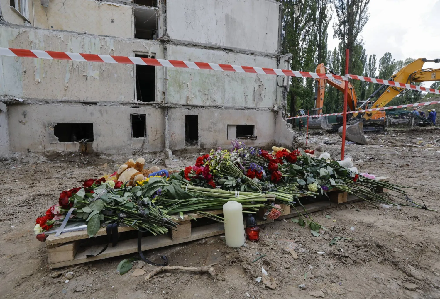وُضعت زهور في موقع هجوم صاروخي روسي على مبنى سكني من 9 طوابق بكييف (إ.ب.أ)