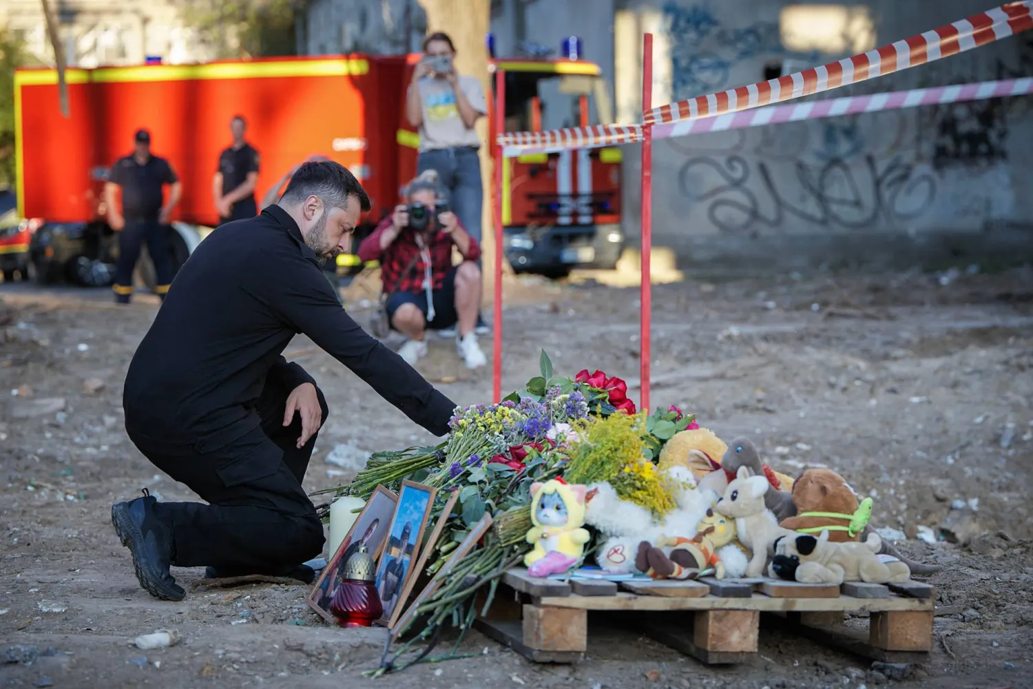 يعرض الرئيس الأوكراني فولوديمير زيلينسكي الزهور تكريماً لذكرى ضحايا منطقة سفياتوشينسكي حيث قُتل 28 شخصاً بينهم 5 أطفال إثر هجوم روسي بكييف في خضم الغزو الروسي لأوكرانيا - أمس (أ.ف.ب)