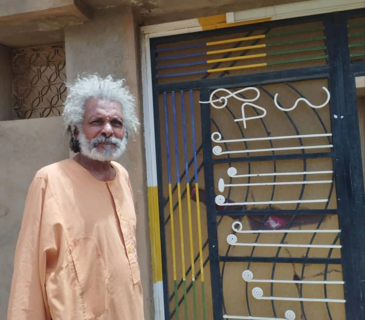 الفنان أبو عركي أمام داره التي لم يغادرها طوال أيام الحرب في العاصمة الخرطوم (الشرق الأوسط)