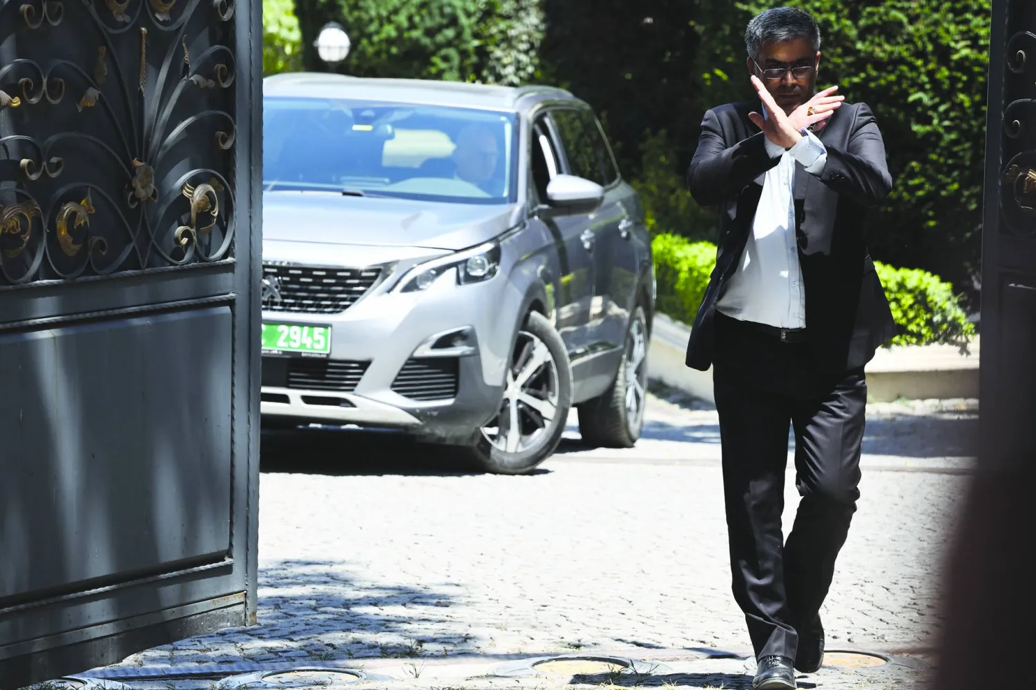 موظف يُشير بيده في أثناء مغادرة وفد أوروبي القنصلية الإيرانية عقب محادثات نووية بإسطنبول في 25 يوليو 2025 (إ.ب.أ)