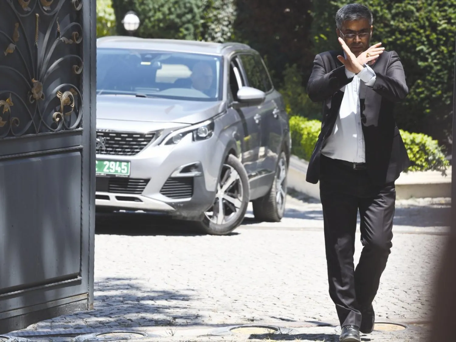 موظف يُشير بيده في أثناء مغادرة وفد أوروبي القنصلية الإيرانية عقب محادثات نووية بإسطنبول في 25 يوليو 2025 (إ.ب.أ)