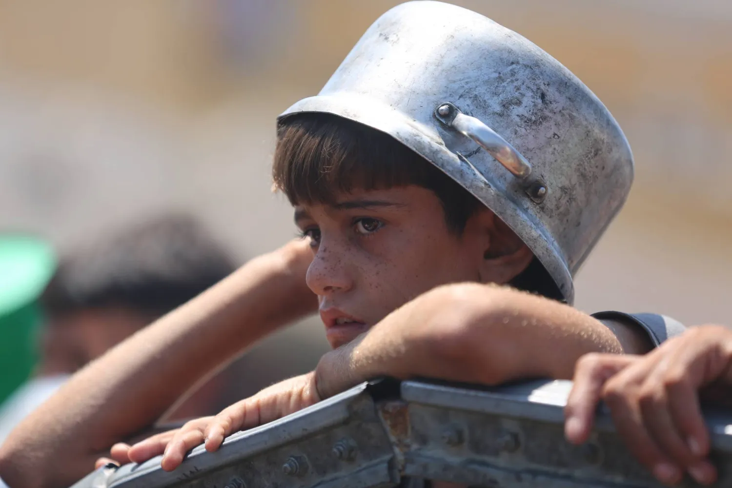 في انتظار الطعام ... طفل فلسطيني يضع قدره على رأسه أمام مطبخ خيري في غزة أمس (د.ب.أ)