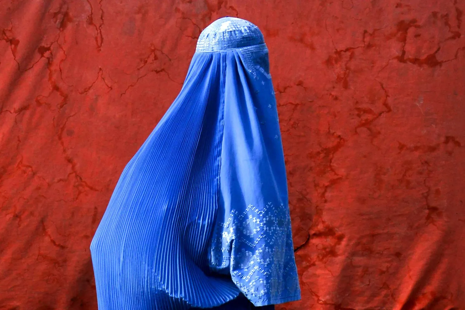 امرأة أفغانية ترتدي البرقع تقف على طول طريق في قندهار - 29 يوليو 2025 (أ.ف.ب)