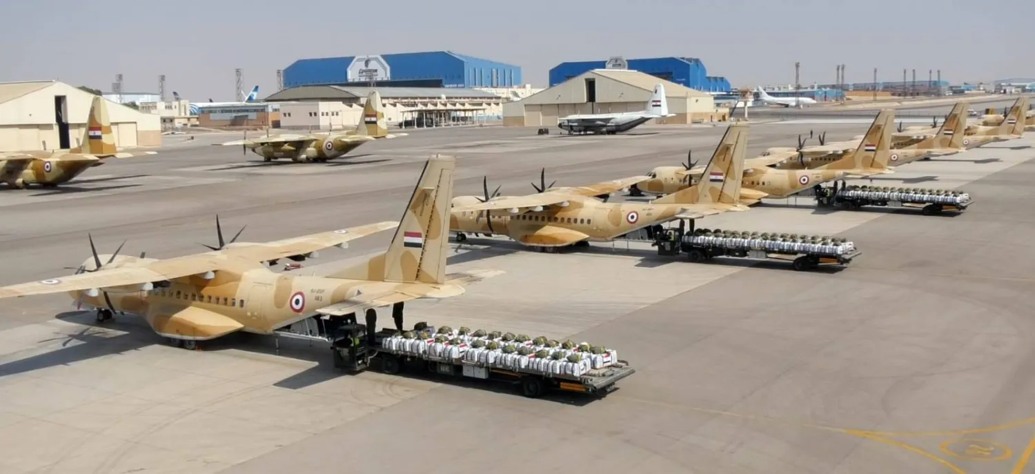 ناقلات تحمل حزم مساعدات أثناء وضعها على متن طائرات عسكرية قبل إسقاطها فوق غزة (الجيش المصري)