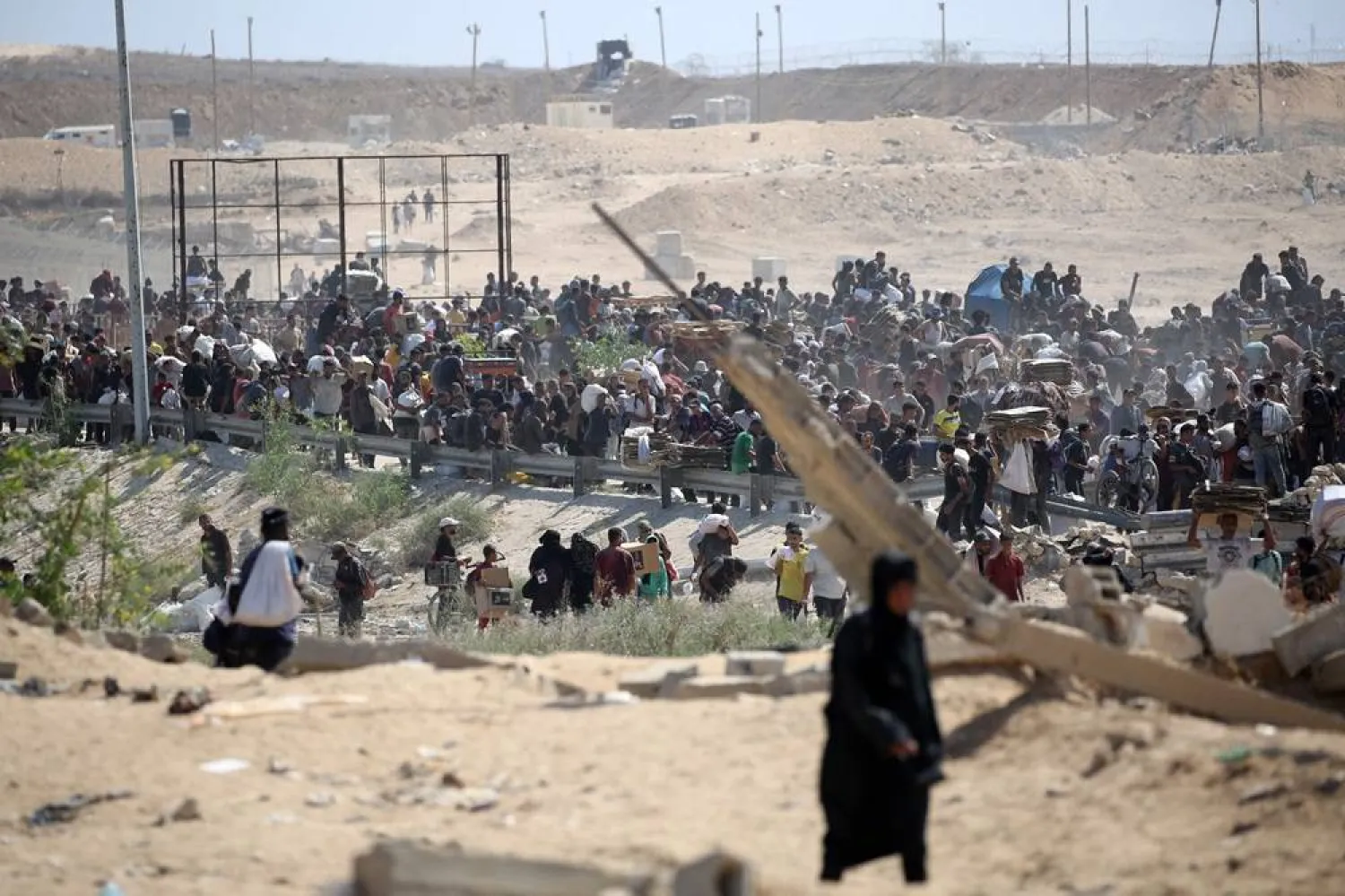 Palestinians return with bags, boxes and wooden pallets from a food distribution point run by the US and Israeli-backed Gaza Humanitarian Foundation (GHF) group, near the Netsarim corridor in the central Gaza Strip on August 3, 2025. (AFP)