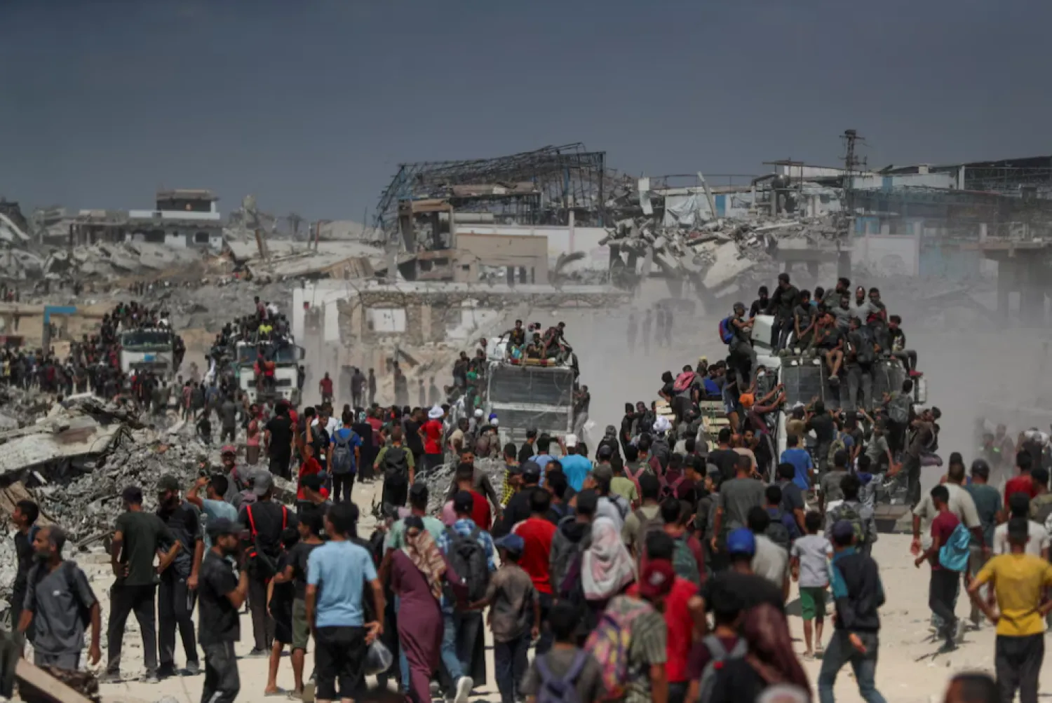 Palestinians climb onto trucks as they seek for aid supplies that entered Gaza through Israel in Beit Lahia, northern Gaza Strip, August 1, 2025. REUTERS/Mahmoud Issa/File Photo