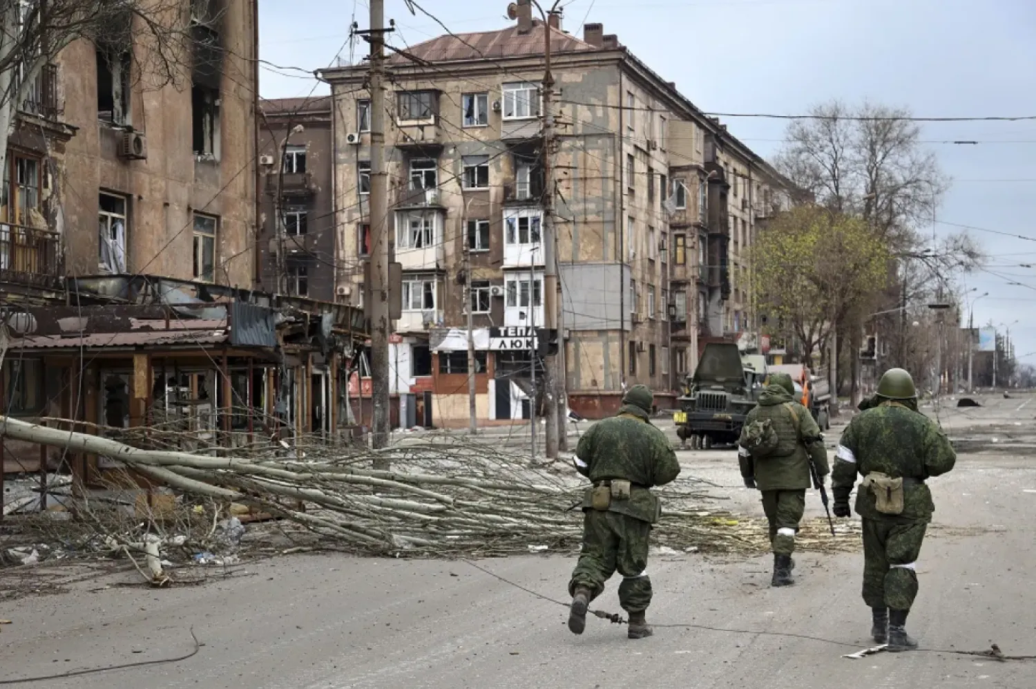 Servicemen of the militia from the Donetsk People's Republic walk past damaged apartment buildings near the Illich Iron & Steel Works Metallurgical Plant, the second-largest metallurgical enterprise in Ukraine, in an area controlled by Russian-backed separatist forces in Mariupol, Ukraine, Saturday, April 16, 2022. (AP)
