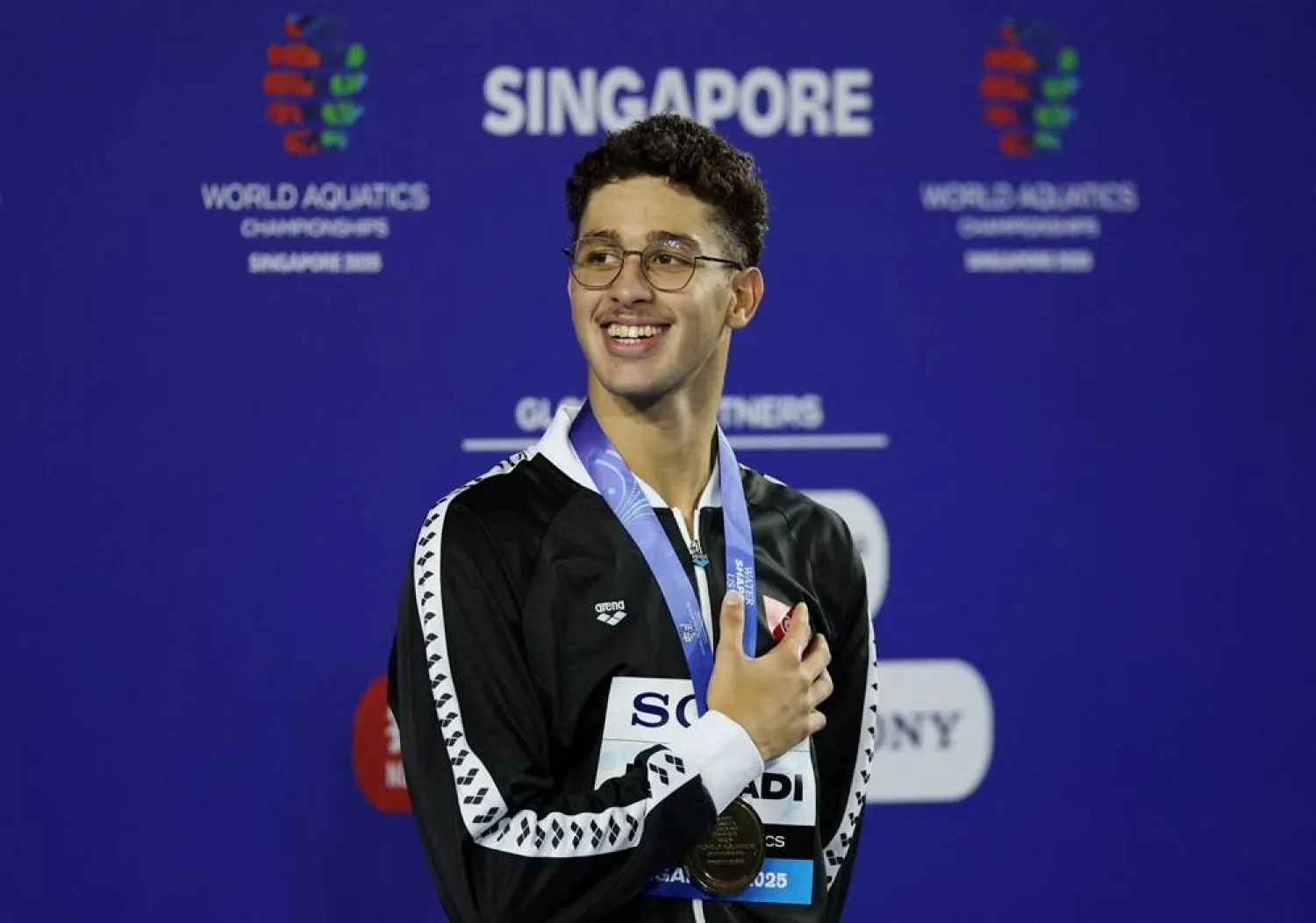  Swimming - World Aquatics Championships - Men 1500m Freestyle - World Aquatics Championships Arena, Singapore - August 3, 2025 Gold medalist Tunisia's Ahmed Jaouadi celebrates on the podium. (Reuters)