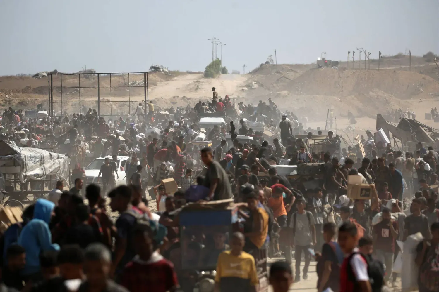 Dün Gazze Şeridi'nin orta kesimlerindeki Netzarim Koridoru’nda Gazze İnsani Yardım Vakfı’ndan aldıkları yardım malzemelerini taşıyan Filistinliler (AFP)