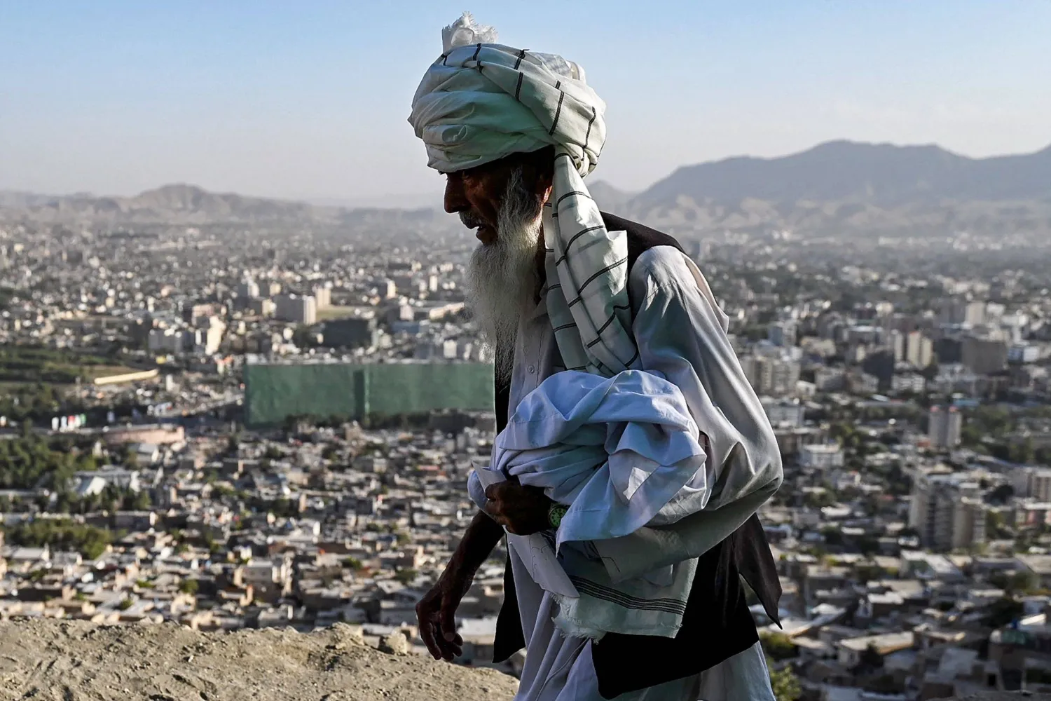 رجل أفغاني يسير على طول تلة تطل على كابل في 3 أغسطس 2025 (إ.ب.أ)
