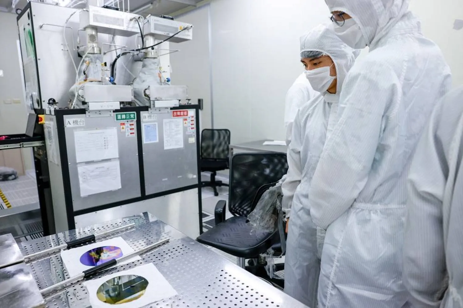 Students dressed in white protective suit and a face mask visit a clean room as part of a summer camp organized by US chip designer Synopsys with the goal to attract more youth to Taiwan's semiconductor industry, in Hsinchu, Taiwan July 18, 2025. (Reuters) 