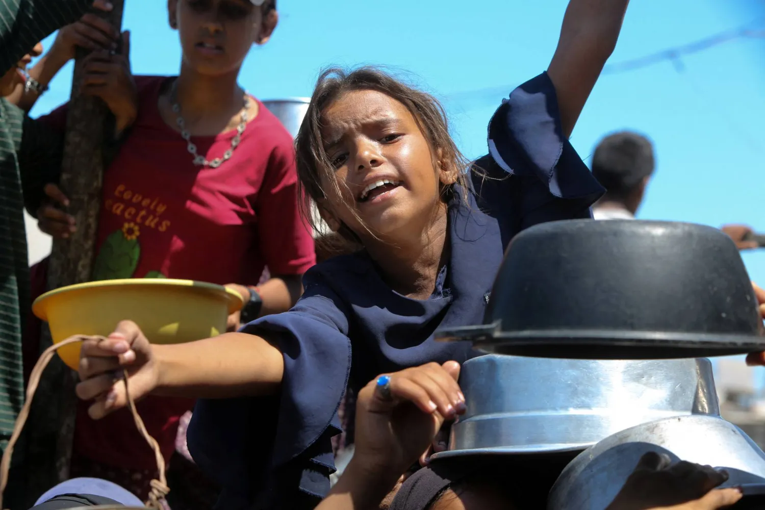 أطفال فلسطينيون يكافحون من أجل الحصول على الطعام في خان يونس بقطاع غزة (رويترز)